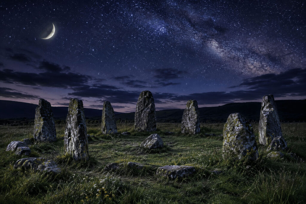 A circle of ancient stone pillars in a field under a starry sky